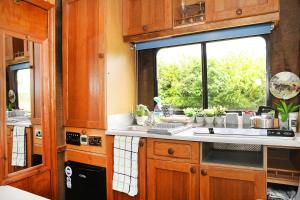 a kitchen with a sink and a window at Tarka Trail Horsebox - Hot Tub & Pet proof garden in Littleham +29 photos