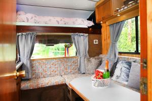 an interior of an rv with a bed and a table at Tarka Trail Horsebox - Hot Tub & Pet proof garden in Littleham