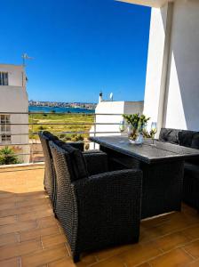 a patio with a table and chairs on a balcony at Vila Rio DOuro in Ferragudo