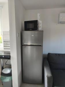 a small refrigerator with a microwave on top of it at Melba Vendégház in Dömsöd