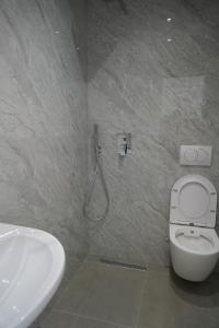 a bathroom with a white toilet and a sink at Summer Tale Rooms in Tale +25 photos