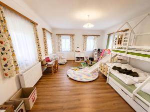 a room with two bunk beds and a living room at Chalet Rebenruhe Südsteiermark in Praratheregg