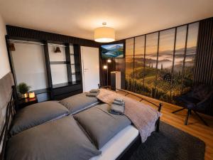 a bedroom with a bed with a large painting on the wall at Chalet Rebenruhe Südsteiermark in Praratheregg
