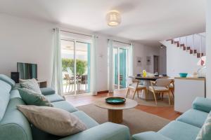 a living room with a blue couch and a table at L&A Villa Prainha 3 Bedrooms Heated Pool 5 m walking to the beach in Alvor