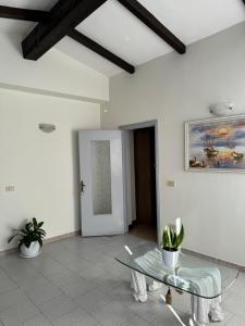 a living room with a glass table and a painting at Villa Emma Durrës in Durrës