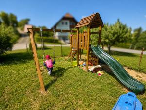 a play set with a swing and a playground at Chalet Rebenruhe Südsteiermark in Praratheregg