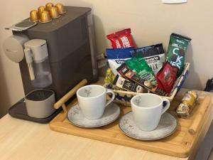 two cups on a wooden tray next to a coffee maker at Flat Mont Blanc Premium in Ribeirão Preto +42 photos