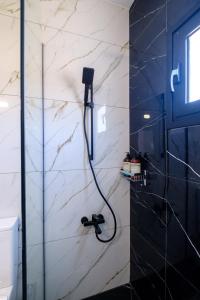 a shower in a bathroom with a black and white marble wall at Sea Breeze Studios in Pervolia +31 photos