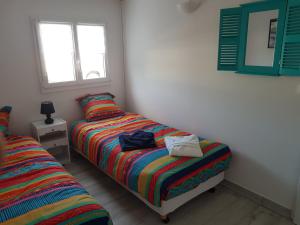 a bedroom with two twin beds and a mirror at La Minoterie 2 Chambre d'hôtes in Le Palais