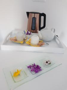 a white shelf with a tea pot and flowers on it at La Minoterie 2 Chambre d'hôtes in Le Palais
