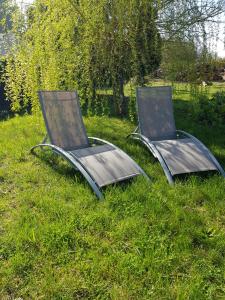 two chairs sitting in the grass in a field at La Minoterie 2 Chambre d'hôtes in Le Palais