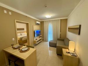 a large living room with a couch and a television at Flat Mont Blanc Premium in Ribeirão Preto