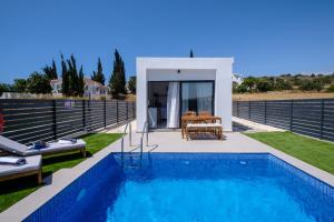 a villa with a swimming pool and a house at Sea Breeze Studios in Pervolia