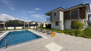 a swimming pool in front of a house at Nest Park Side in Side