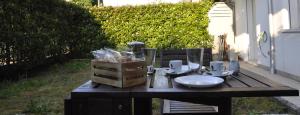 a wooden table with plates and glasses on it at Appartamento moderno e spazioso con giardino privato in Selvazzano Dentro