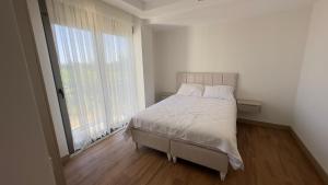 a white bedroom with a bed and a large window at Nest Park Side in Side +32 photos