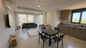 a kitchen and a living room with a table and chairs at Nest Park Side in Side