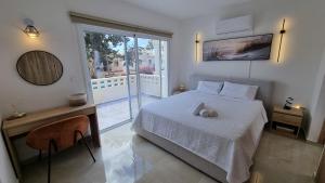 a bedroom with a white bed and a balcony at Nerina 3 Luxury Villa in Paphos +45 photos