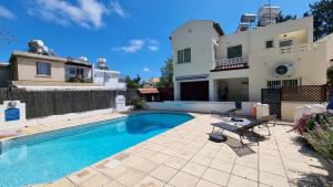 a swimming pool in front of a house at Nerina 3 Luxury Villa in Paphos