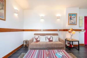 a living room with a couch and a table at Résidence Les Aiguilles de Warens - Combloux in Combloux
