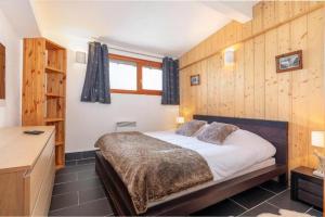 a bedroom with a bed in a room with wooden walls at Résidence Les Aiguilles de Warens - Combloux in Combloux