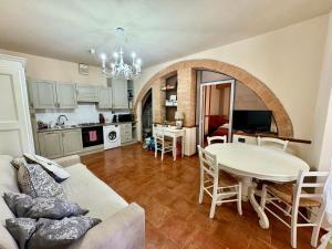 a living room with a white table and a kitchen at Appartamento I 2 Archi in Siena