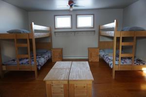 a room with bunk beds and a table and a fan at HI Rossburn 9 Finger Ranch in Rossburn