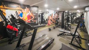 a gym with cardio machines and a painting of people at Apart hotel Mercure boa viagem in Recife