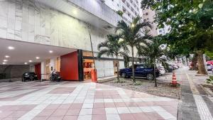 a building with a car parked in front of it at Apart hotel Mercure boa viagem in Recife