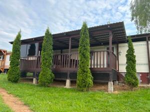 a house with a porch and a row of trees at Mobilheim Výr in Výrovice