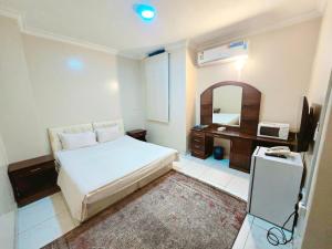 a bedroom with a bed and a desk and a mirror at فندق الجنوب Al janob hotel in Riyadh +38 photos