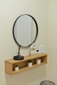 a round mirror on a shelf with potted plants at Ivy apartman Vršac in Vršac +31 photos