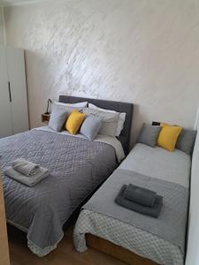 two beds sitting next to each other in a bedroom at Ivy apartman Vršac in Vršac