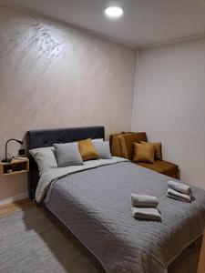 a bedroom with a bed with two towels on it at Ivy apartman Vršac in Vršac