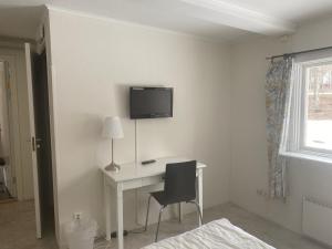 a room with a desk and a tv on the wall at Björklunden in Sollefteå +11 photos