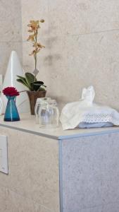a white table with a shelf with glasses and a plant at Les Fougères in Sévrier +20 photos