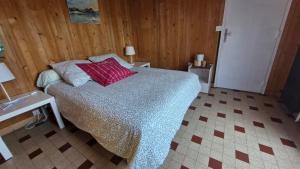 a bedroom with a bed with red pillows on it at Les Fougères in Sévrier