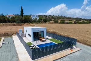 a house with a swimming pool in a field at Sea Breeze Studios in Pervolia