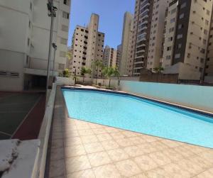 a swimming pool on the side of a building at Apartamento Prático Completo in Goiânia