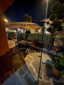 a patio with a table and an umbrella at night at Casa Di Francia in Pontedera