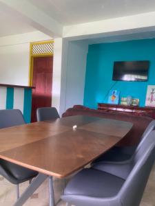 a conference room with a wooden table and chairs at Anthurium Apartment in Roseau