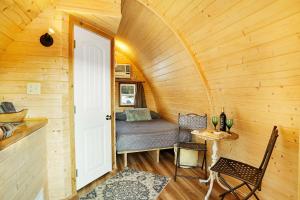 a bedroom in a tiny house with a bed and a table at The Cranny at Kimberly Creek Retreat in Ashland