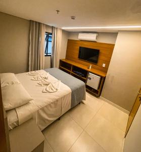 una camera d'albergo con un letto e una TV a schermo piatto di HIMMA Hotel a Aparecida Altre 6 foto