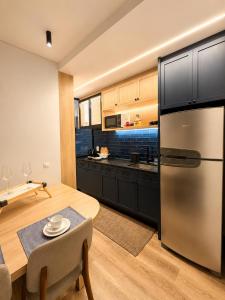 a kitchen with a stainless steel refrigerator and a table at apartamento vitória 101 in Pomerode