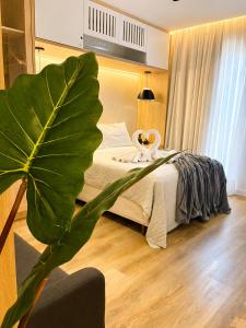 a bedroom with a bed with a large green plant at apartamento vitória 101 in Pomerode