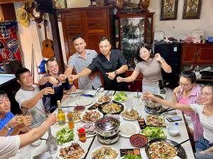 a group of people sitting around a table with food at Bungalows Hill Mũi Né in Ấp Thiện Long
