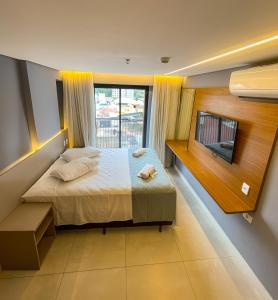 una camera da letto con un letto, una TV e una finestra di HIMMA Hotel a Aparecida