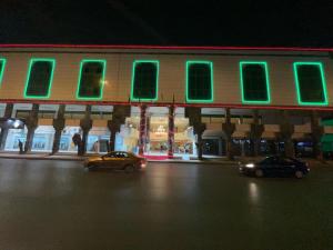 a building with green lights on the side of a street at فندق الجنوب Al janob hotel in Riyadh