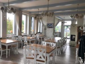 a dining room with tables and chairs and windows at MODRA SOBÓTKA - Perła KASZUB in Ręboszewo