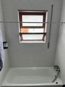 a bathroom with a white tub and a window at Azul 31 in Lajes das Flores